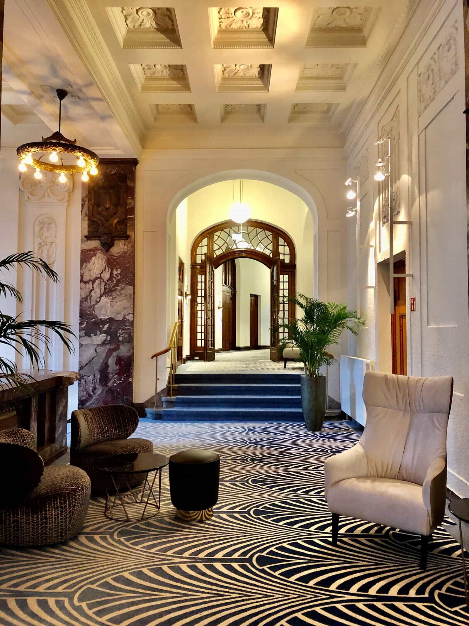 interior design of a hotel hallway with a wooden stained glass arch and marble accent wall